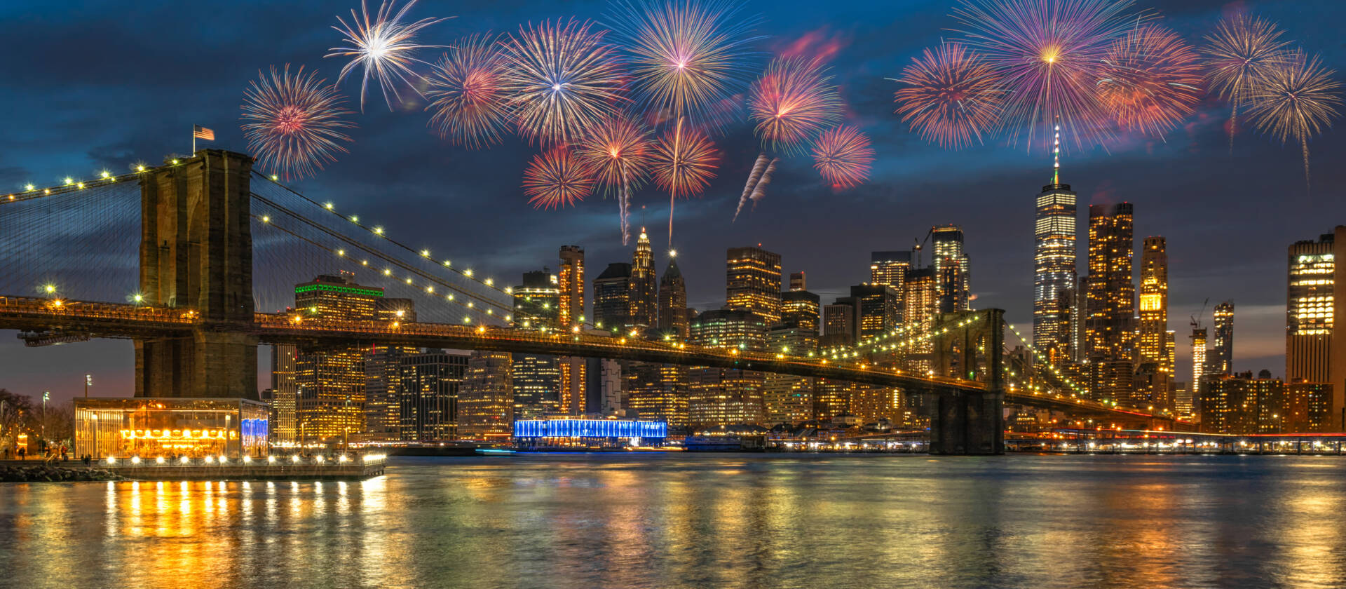 Banner Multicolor Firework Celebration over New york Cityscape with Brooklyn Bridge over the east river at the twilight time, USA downtown skyline,  4th of July and Independence day concept
